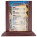 A Mahogany wood Menu Solutions table tent holding a menu on a table.