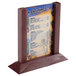 A mahogany wood table tent with a menu in it.