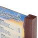 A Menu Solutions mahogany wood table tent holding a menu card.