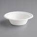 A close up of a white EcoChoice Compostable Sugarcane bowl with a white rim on a gray surface.