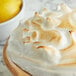 A lemon meringue pie with a lemon wedge on top.