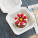 An EcoChoice white bagasse take-out container with a chocolate cake inside.