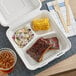 A white EcoChoice compostable takeout container with ribs and coleslaw.