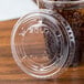 A Solo clear plastic lid on a plastic cup with brown soda.