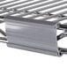 A close-up of a metal shelf with a metal label holder attached.