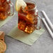 A glass mug with a Choice Sage 2-Ply Beverage napkin and a lemon slice on top of it.