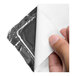A replacement heater blanket with a metallic backing and white cover being peeled back by a hand.
