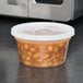 A plastic container of beans sitting on a counter.