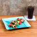 A CAC Japanese Style stoneware plate with food on a table next to a drink.