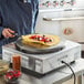 A chef using a Carnival King crepe maker to cook a pancake with fruit.