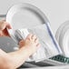 A person wiping a white plate with a blue-striped Choice herringbone kitchen towel.