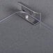 A clear plastic plate with a metal clip and a screw.