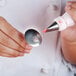 A person holding a white Ateco flower nail.