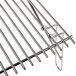 A stainless steel grill grate with a metal handle.