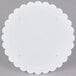 A white round Wilton cake separator plate with scalloped edges.