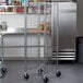 A Metro RE1 unassembled wire cart with metal shelves on wheels.