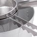 A close-up of a stainless steel AllPoints Strainer with a metal handle.