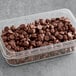 A plastic container of HERSHEY'S milk chocolate mini baking kisses on a counter.