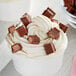 A cup of ice cream with KIT KAT® chocolate squares on top.
