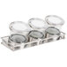 A group of glass containers with notched lids on a metal tray.