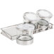 A Cal-Mil stainless steel tray holding three glass jars with notched lids.