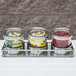 A Cal-Mil horizontal display with three notched glass jars filled with fruit on a counter.