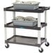 A Lakeside plastic utility cart with trays of dishes on it.