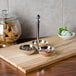 A wooden tray with three stainless steel bowls on it.