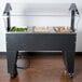 An Advance Tabco buffet table with food on it.