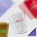 A clear Cambro plastic tumbler with pink text.