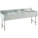 A stainless steel Advance Tabco underbar sink with four compartments and two drainboards.