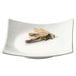 A white square CAC porcelain plate with sushi on it.