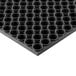 A black circular Notrax anti-fatigue mat with holes in it.