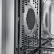A stainless steel interior of a Convotherm C4ED20.10GS liquid propane half size roll-in boilerless combi oven with ventilation and fan components visible.