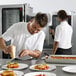 A man in a white shirt using a Convotherm Maxx Pro electric combi oven to prepare a plate of food.