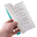 A hand holding the book "Designing, Constructing & Renovating a Food Service Establishment"