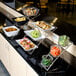 A display of food on a three-tier chrome arch display stand.