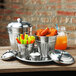 An American Metalcraft mini stainless steel trash can lid on a metal container full of vegetables.