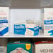 A white shelf with boxes of Medi-First Alcohol Prep Pads.