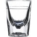 A close up of a Libbey fluted shot glass with clear liquid inside.
