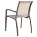 A Grosfillex Sunset Cognac outdoor stacking armchair with a beige seat and back on a white background.