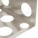 A metal corner shelf with circular holes for bottles.