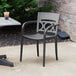 A Grosfillex Moon titanium gray outdoor stacking chair on a patio.