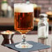 A Libbey Lexington goblet filled with amber liquid on a table.