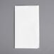 A white linen-feel folded dinner napkin on a gray surface.