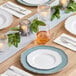 A table set with white plates and Choice White Linen-Feel Dinner Napkins with a fork and knife on top.