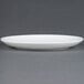 A white CAC European bone china coupe plate with a rim.