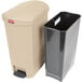 A tan Rubbermaid Slim Jim end step-on trash can with a black lid.