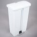 A white plastic Rubbermaid Slim Jim trash can with a front step-on lid.