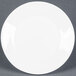 An Arcoroc white glass plate with a small rim on a gray surface.